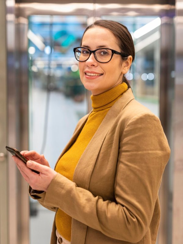 tiro-medio-mujer-sonriente-sosteniendo-telefono_23-2148815606